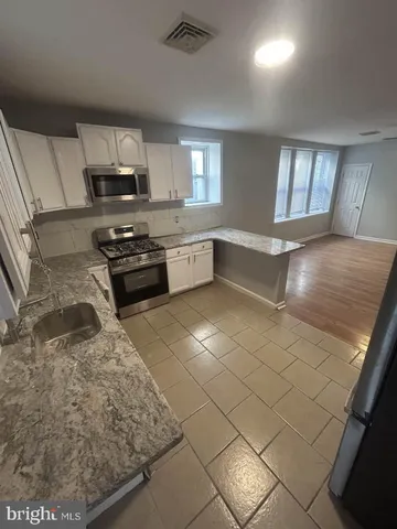 a kitchen with stainless steel appliances granite countertop a sink stove and microwave