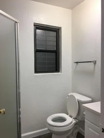 a white toilet sitting next to a shower