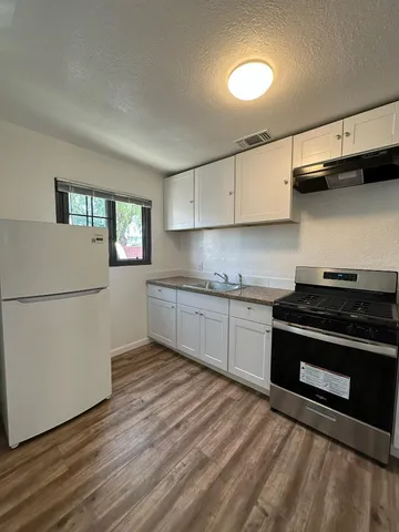 a kitchen with granite countertop a stove and a sink