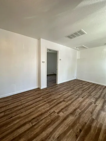 a view of empty room with wooden floor