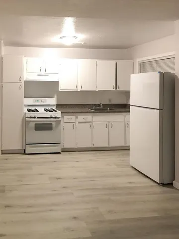a kitchen with a refrigerator stove and white cabinets