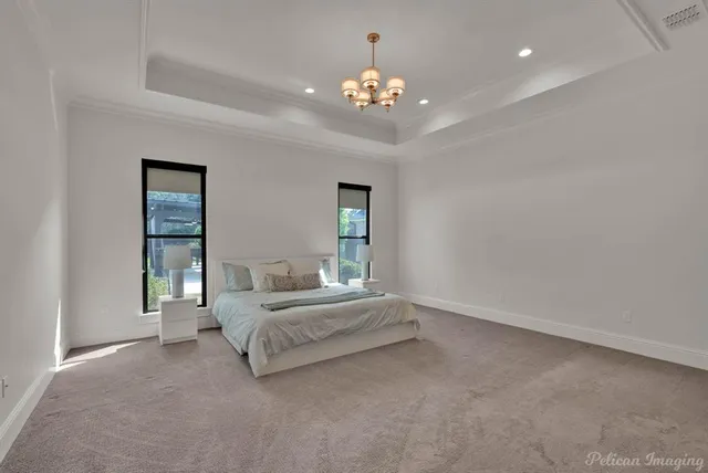 a spacious bedroom with a bed and a chandelier