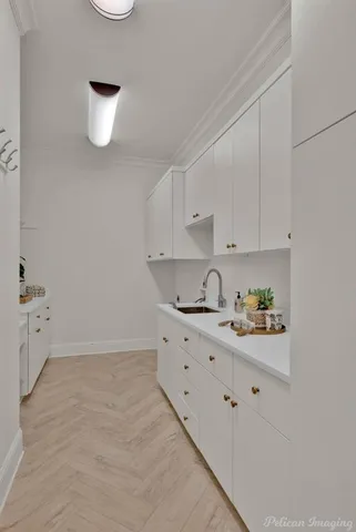 a kitchen with white cabinets and window