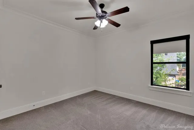 an empty room with a window and a fan