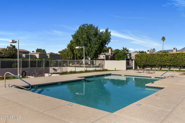 a view of a patio with chairs and table with swimming pool