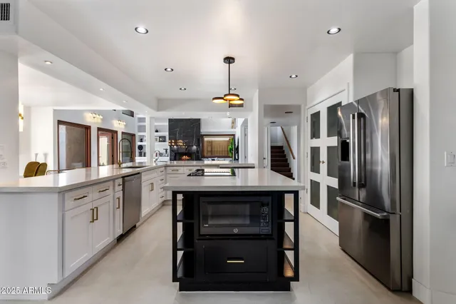 a kitchen with kitchen island a sink stainless steel appliances and cabinets