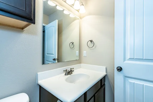 a bathroom with a sink and a mirror with toilet