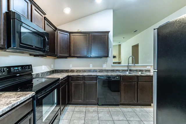 a kitchen with stainless steel appliances granite countertop a stove microwave and sink