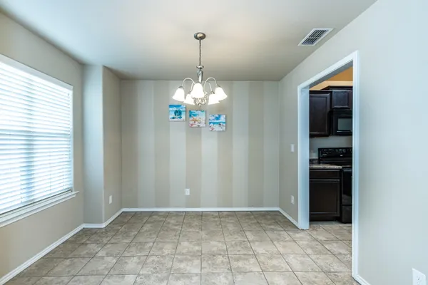 a view of an empty room with window and cabinet