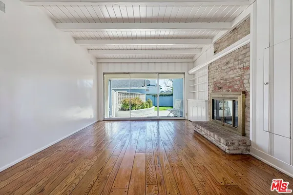 wooden floor fireplace and natural light in room