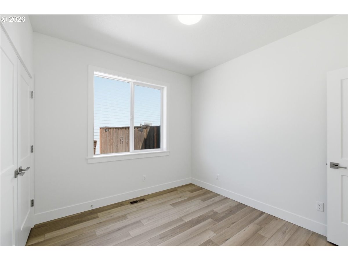 2147 Northeast Spitz Road Canby, OR 97013 - Photo 32 of 48 a view of an empty room with wooden floor and a window