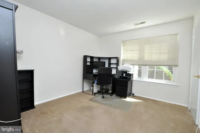 a view of a workspace with furniture and a window