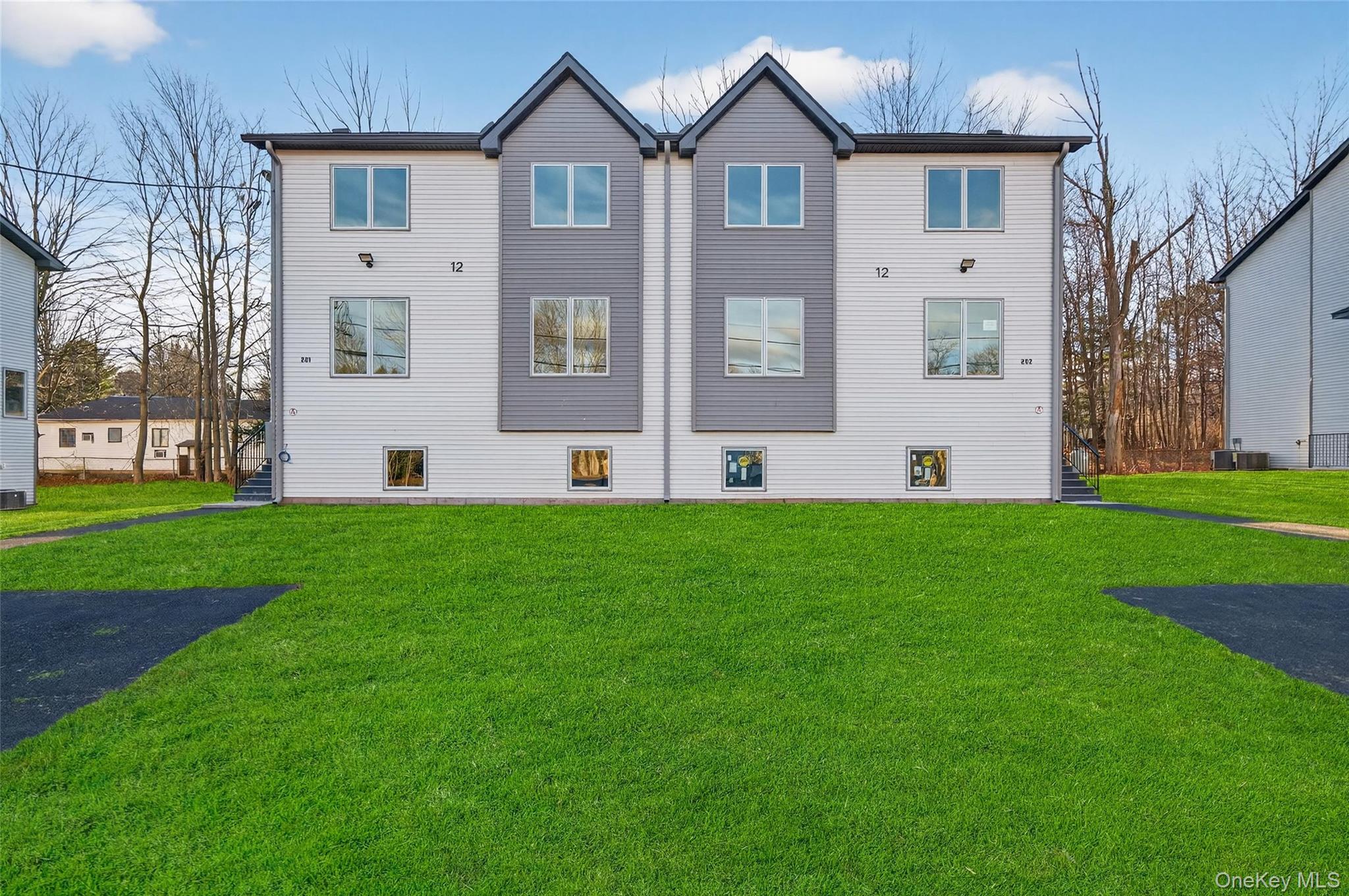 a front view of a house with a garden and yard