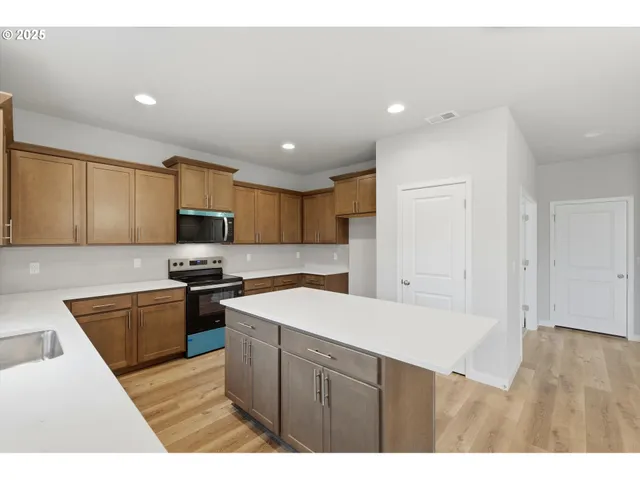 a kitchen with stainless steel appliances granite countertop a sink stove and refrigerator