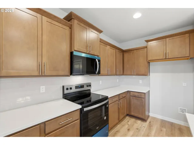 a kitchen with stainless steel appliances granite countertop a sink stove and microwave