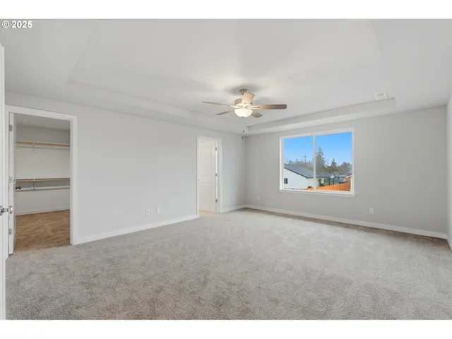 a view of an empty room with a chandelier fan