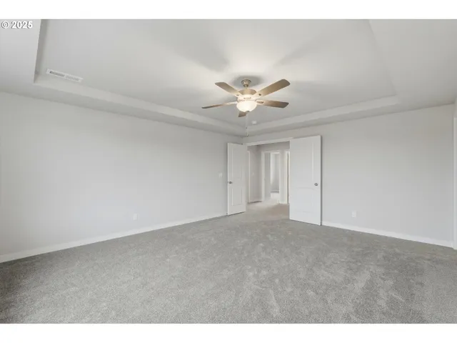 a view of an empty room with a ceiling fan