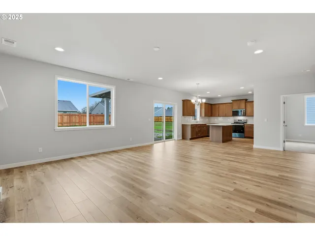 a view of empty room with wooden floor and windows