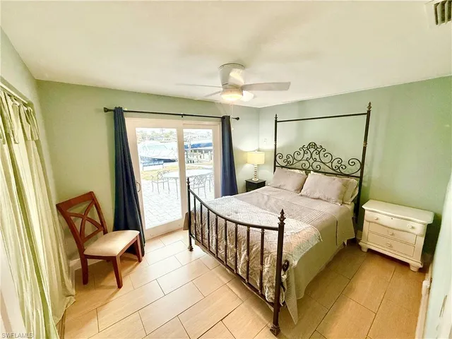 a bedroom with a bed a chair and next to a window