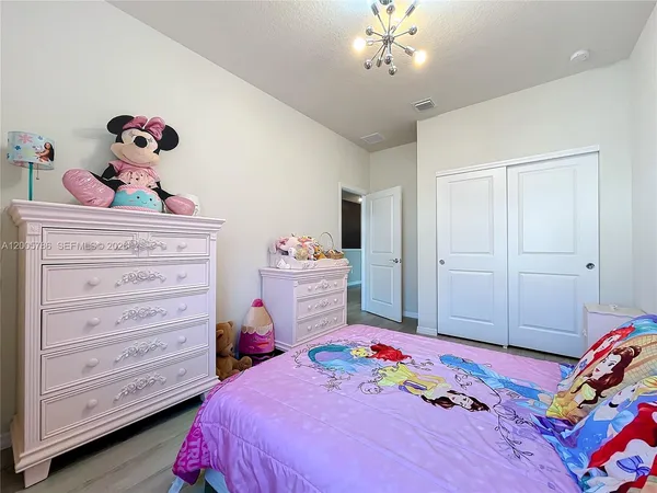 a bedroom with a large bed and a chandelier