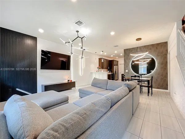 a living room with couches and kitchen view