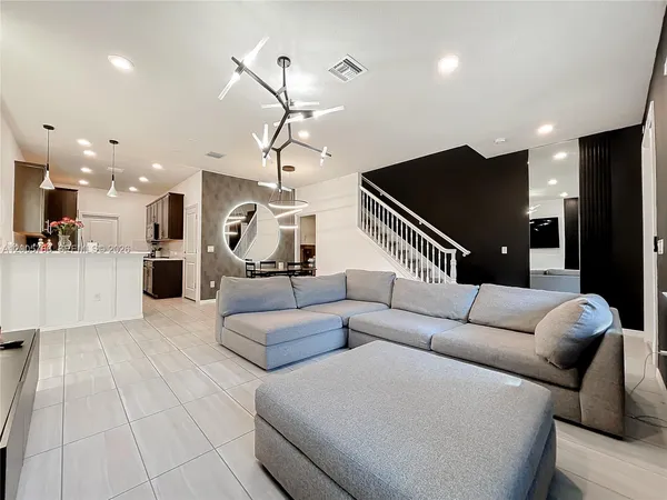 a living room with furniture a dining table and chairs with wooden floor