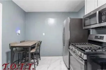 a kitchen with stainless steel appliances granite countertop a stove a refrigerator and a dining table