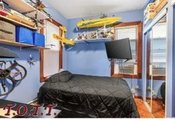 a bedroom with a bed and a tv on the dresser