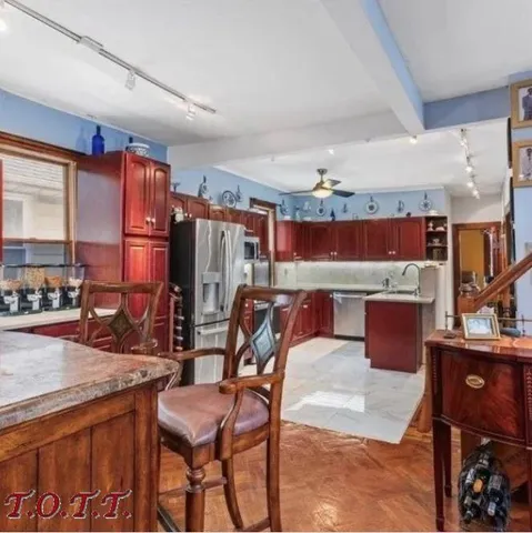 a kitchen with stainless steel appliances kitchen island granite countertop a table chairs in it and a window