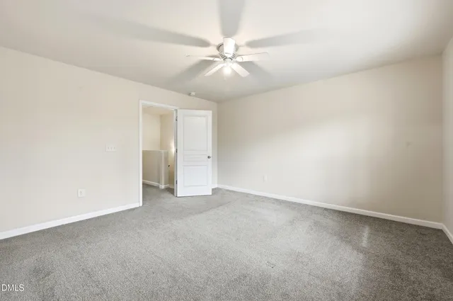 an empty room with a ceiling fan and a window