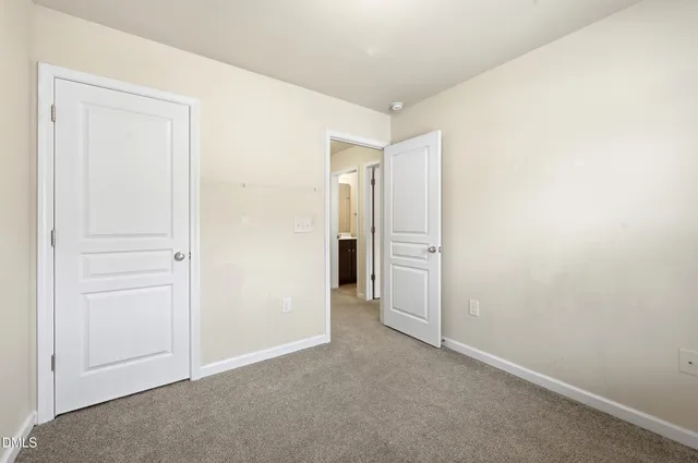 an empty room with closet and a bathroom