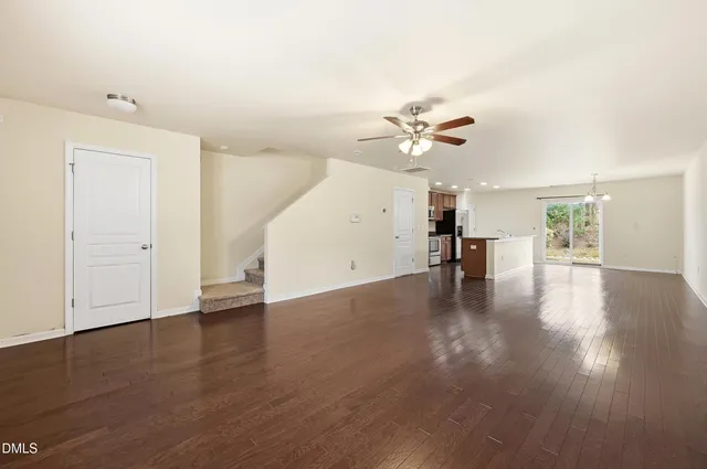 an empty room with wooden floor and ceiling fan