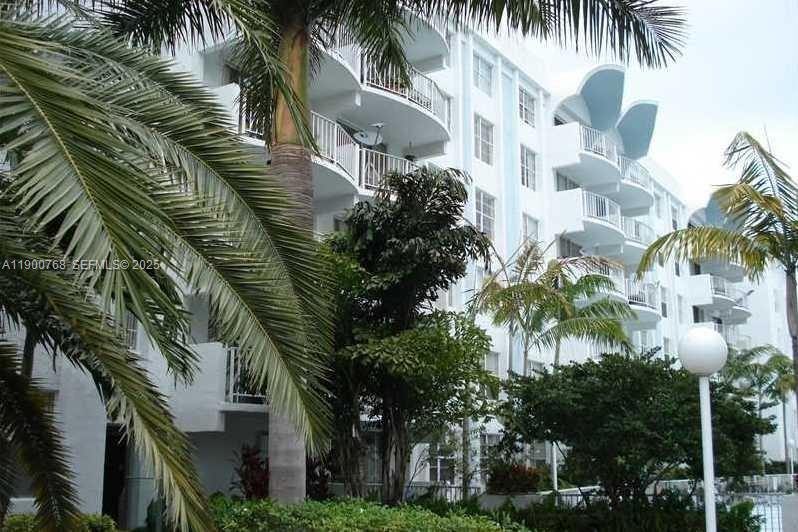 494 Northwest 165th Street, Unit C602 Miami, FL 33169 - Photo 4 of 12 a front view of a house with a palm tree