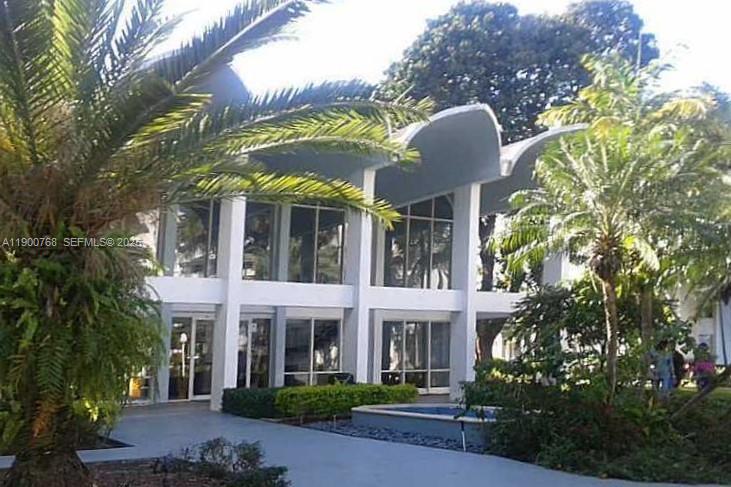 494 Northwest 165th Street, Unit C602 Miami, FL 33169 - Photo 5 of 12 a front view of a house with a yard and garage