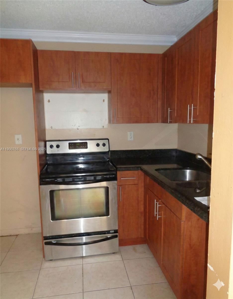 494 Northwest 165th Street, Unit C602 Miami, FL 33169 - Photo 6 of 12 a kitchen with granite countertop a stove and a sink