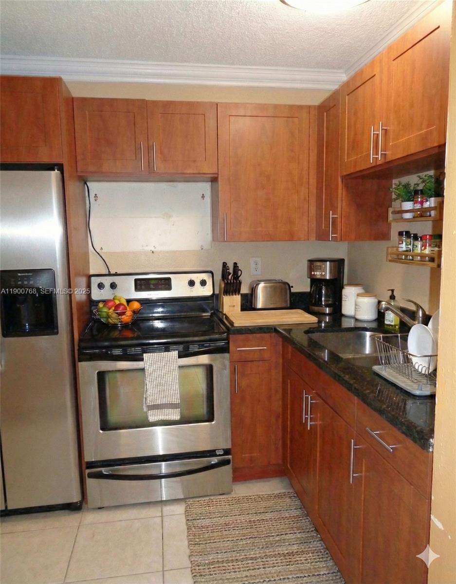 494 Northwest 165th Street, Unit C602 Miami, FL 33169 - Photo 7 of 12 a kitchen with stainless steel appliances granite countertop a stove a sink and a microwave