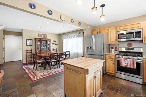 a kitchen with a stove a refrigerator and a dining table
