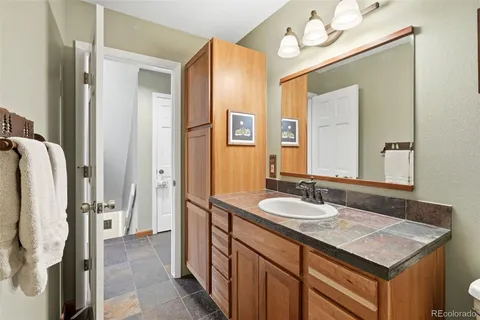 a bathroom with a sink vanity granite and a mirror