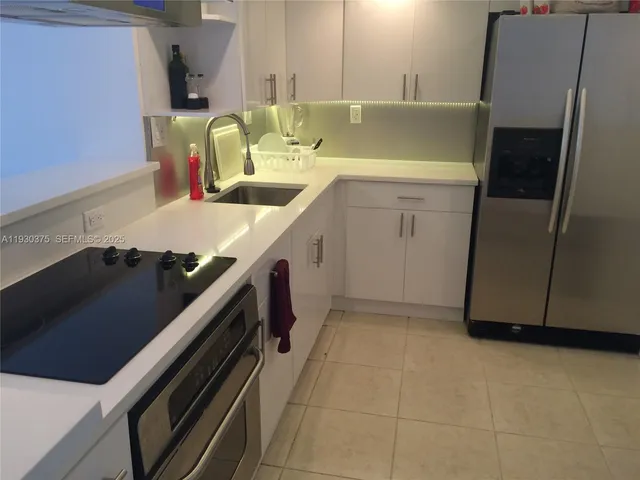 a kitchen with a sink appliances and cabinets