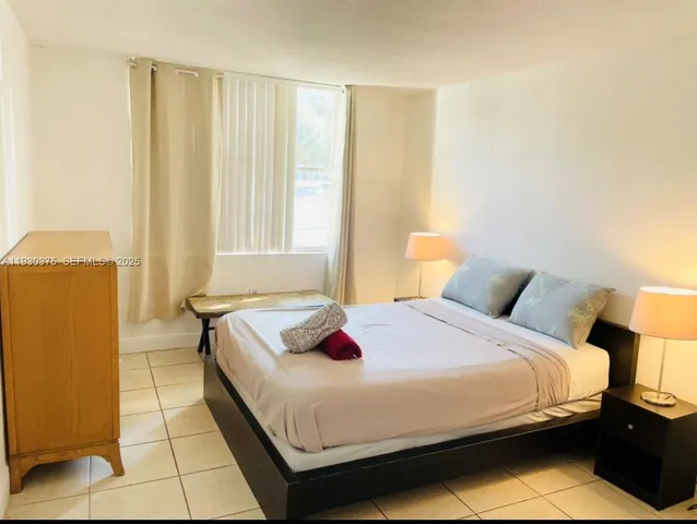 a bedroom with a bed and a potted plant