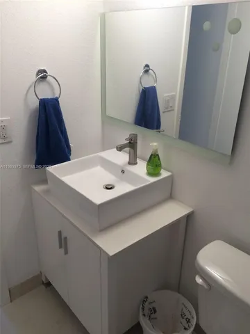 a bathroom with a sink toilet and mirror