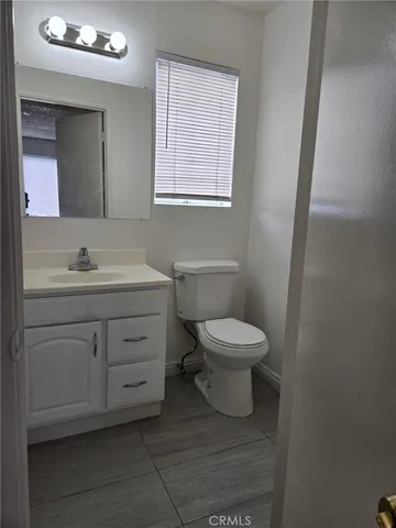 a bathroom with a toilet sink a vanity and mirror