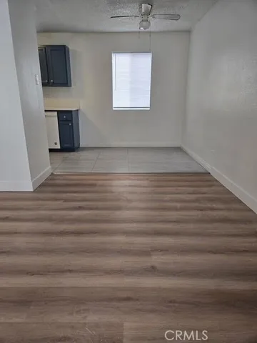 a view of a livingroom with an empty space & a window