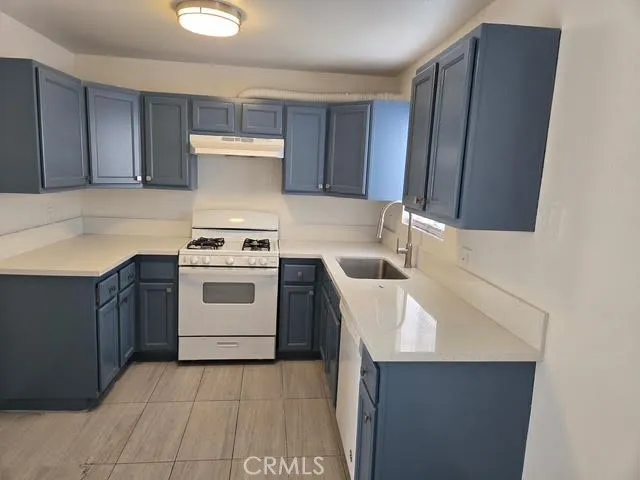 a kitchen with a sink a stove and cabinets