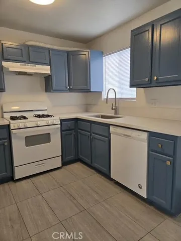 a white kitchen with a sink and dishwasher