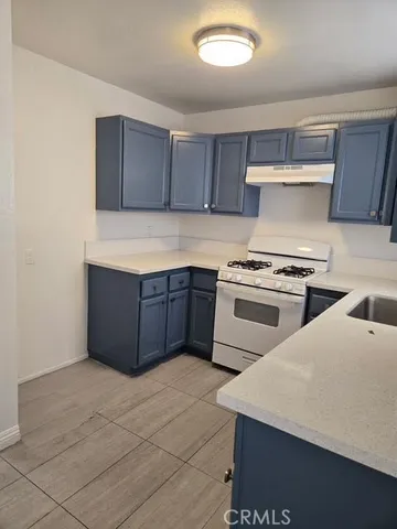 a kitchen with stainless steel appliances a stove a sink and a refrigerator