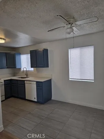 a large kitchen with a stove top oven a sink a counter space and cabinets