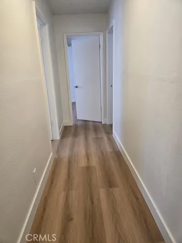a view of a hallway with wooden floor