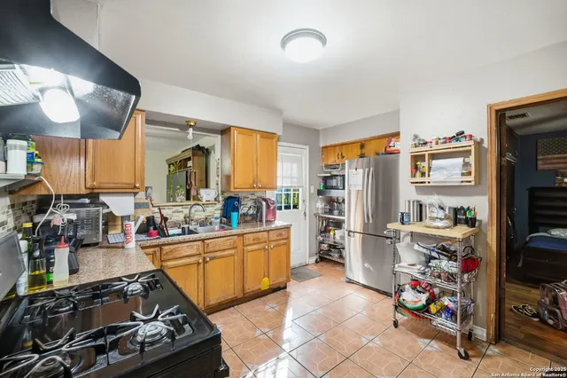 a kitchen with stainless steel appliances a stove a sink and a refrigerator