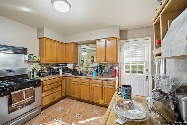 a kitchen with a sink appliances cabinets and a window